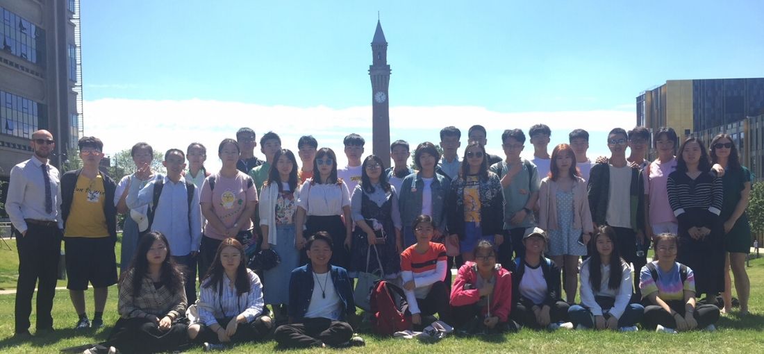 International students standing in the Green Heart with the Old Joe clocktower in the background