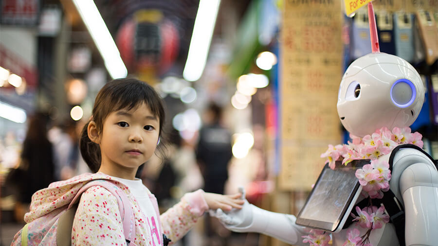 young girl wearing backpacl holds the hand of a humanoid robot