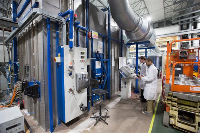 Researchers operating Direct Laser Fabrication machinery
