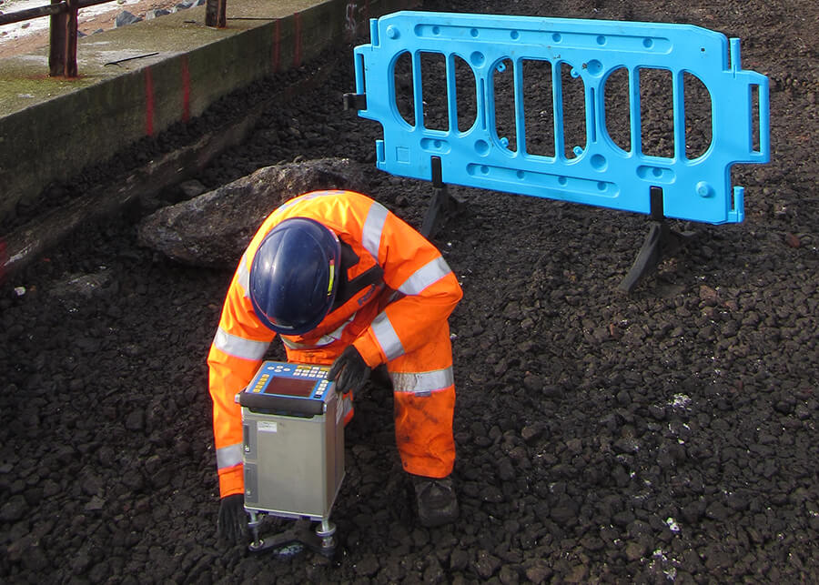 Engineer in high visibility workwear using a gravity sensor
