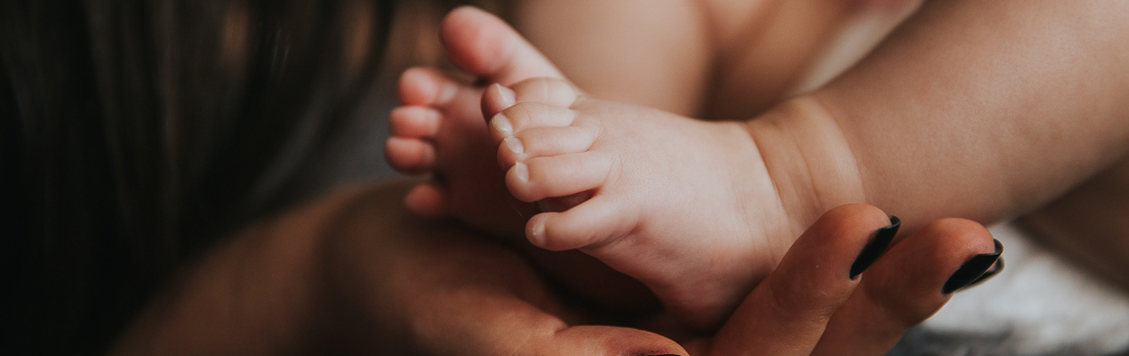 Baby's feet held by adult hand