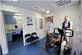Woman undertaking a V02 test on an exercise bike with male researcher next to her