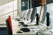 Row of computer screens and keyboards
