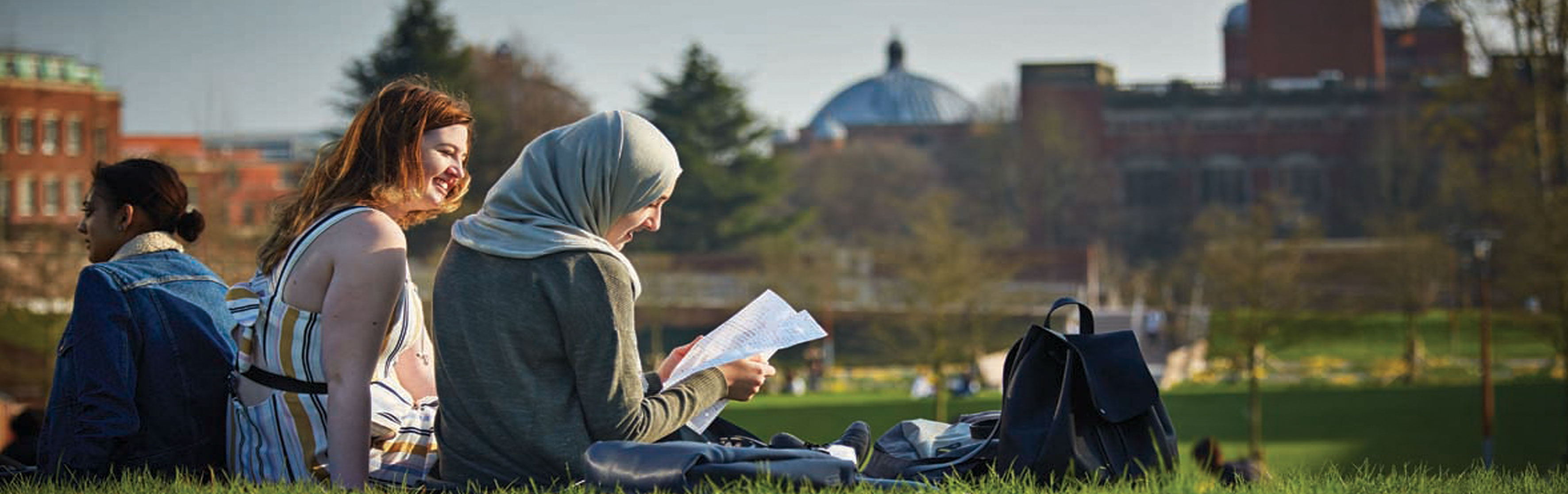 Three female students studying outside on campus
