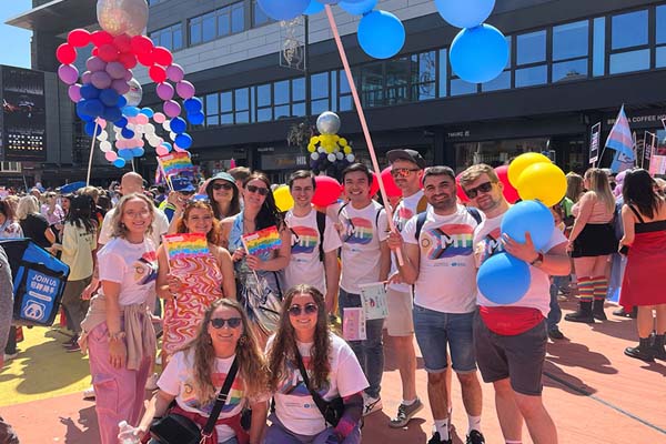 Group of people from IMI at Pride holding balloons