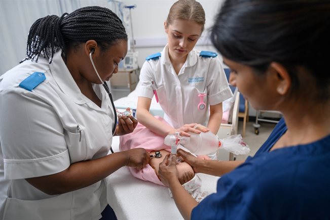 Nurses holding a doll-baby