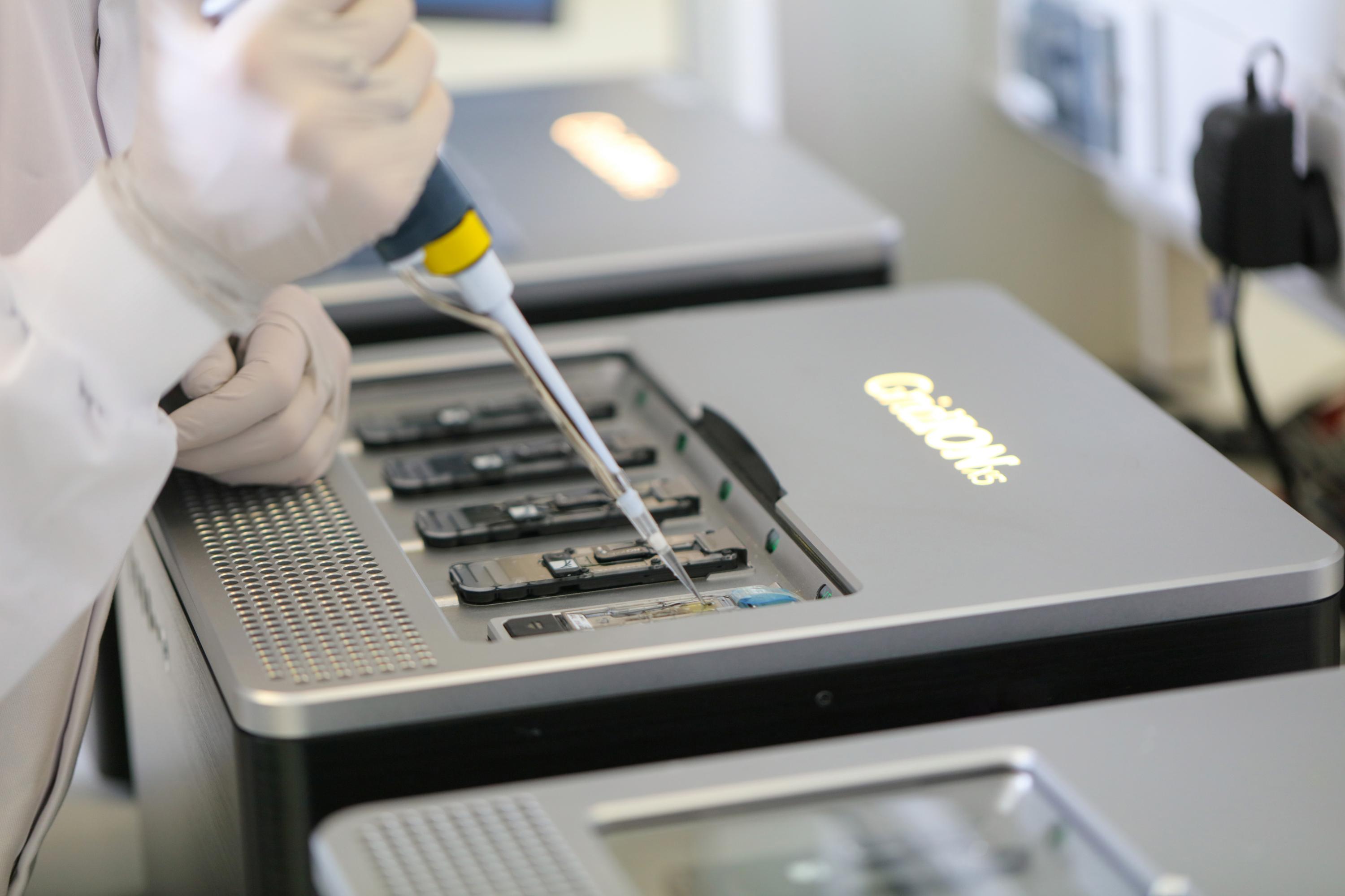 A grid iron close up with a hand holding a pipette.