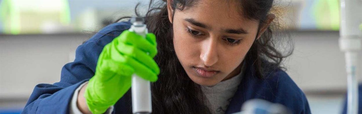 Female Biomedical Science student in lab with a pipette