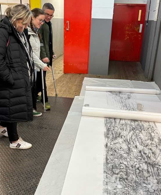 Research group visiting an art studio looking at sketches