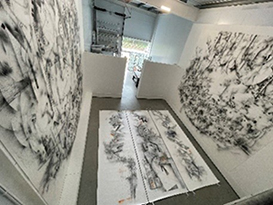 Image of Simon’s gallery from above, showing art on the floor and walls