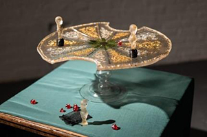 A glass plate on a stand with glass figurines, intended as a game.
