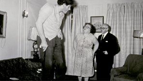Jewish mother and father in black and white photograph looking up towards their tall son