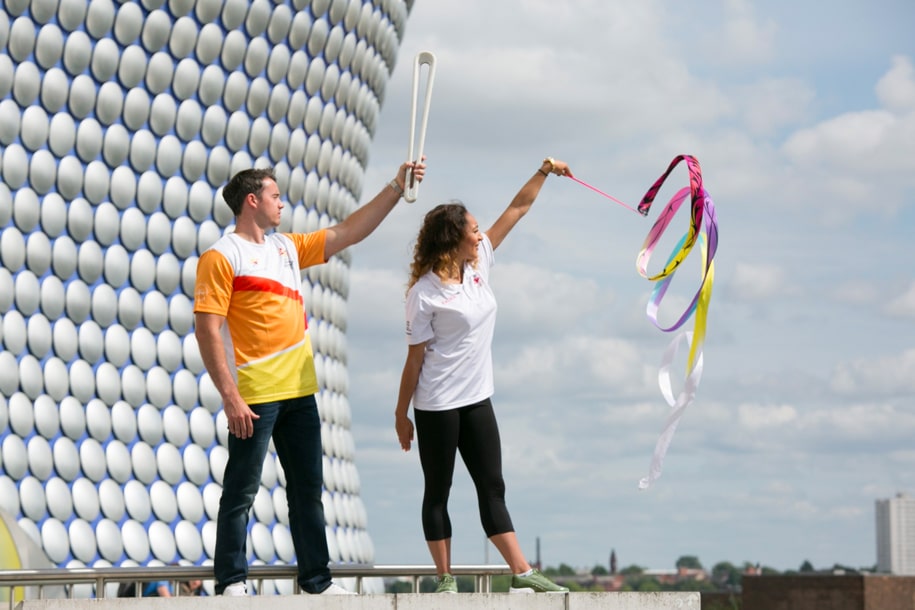Gymnasts Kristian Thomas and Mimi Cesar pose with the Queen’s Baton outside the iconic Bullring in Birmingham