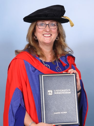The Right Honourable Jacqui Smith dressed in graduation gown and tam, holding her honorary degree