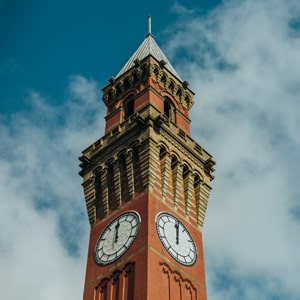Old Joe clocktower against a blue sky with white fluffy clouds