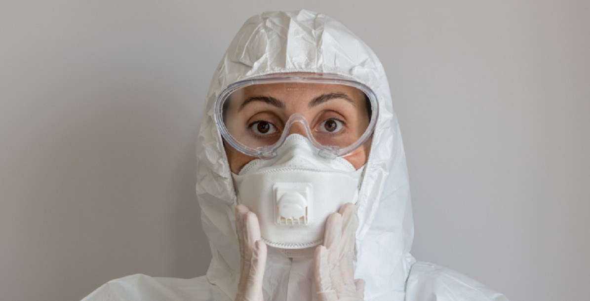 Person wearing facemask and protective clothing
