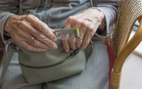 Old lady's hands clutching handbag