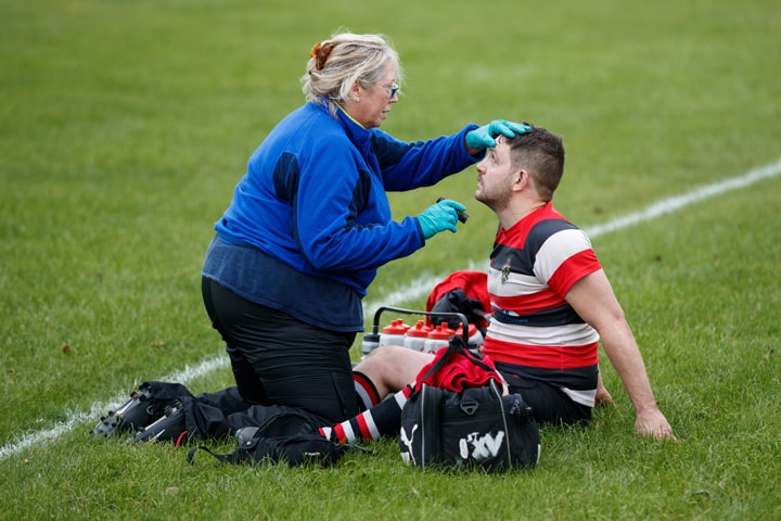 Medic assessing rugby player for concussion