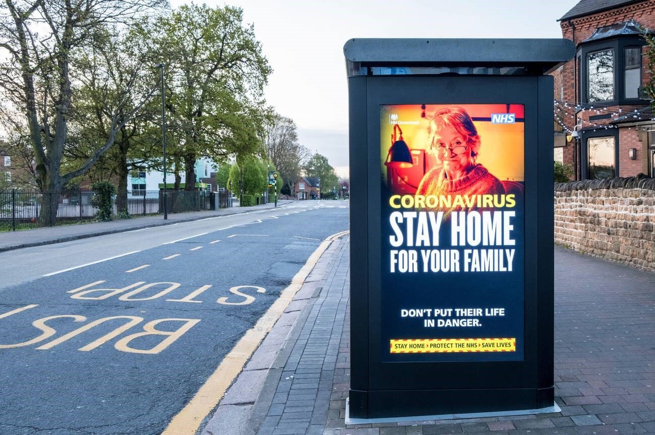 Stay Home For Your Family awareness sign at bus stop