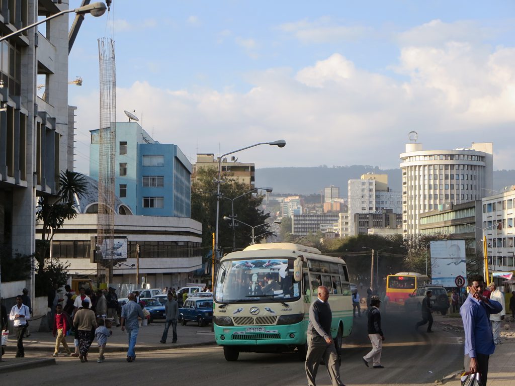 A bus drives down Gambia Street in downtown Addis Ababa, Ethiopia, spewing black exhaust fumes as pedestrians walk nearby