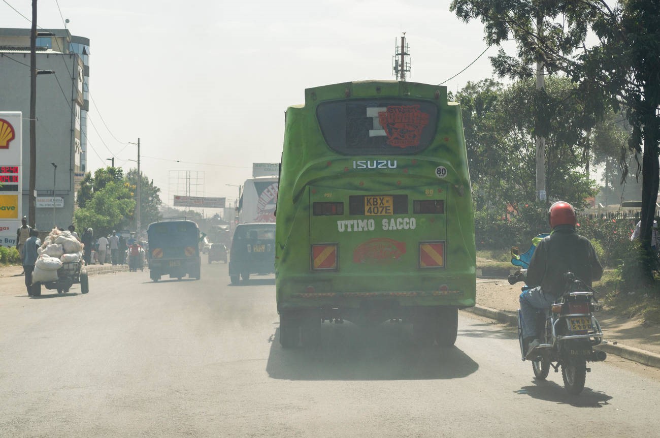 A bus drives along a road spewing a large amount of exhaust fumes into the air in Nairobi, Kenya