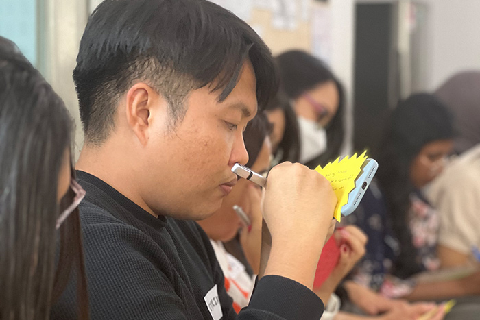 A participant drawing on a note during a teaching session