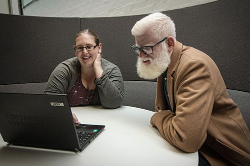 Rachel Hewett looking at a computer with Hasan, a contributor to the Unfiltered Lives campaign