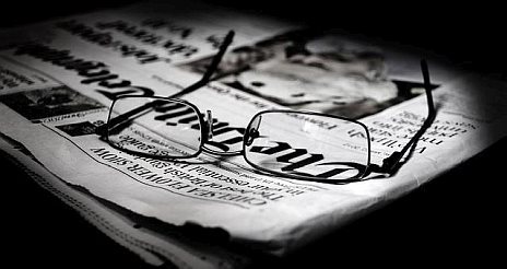 Spectacles resting on top of a folded newspaper