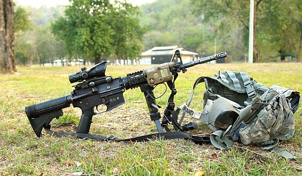 An automatic machine gun set up on grass