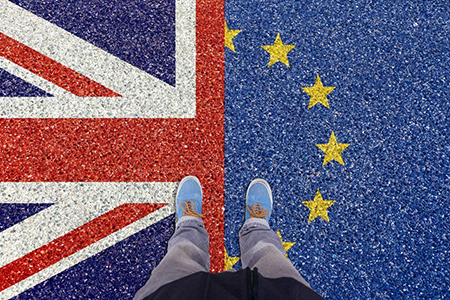Image of feet on half an image of UK flag and half on EU flag
