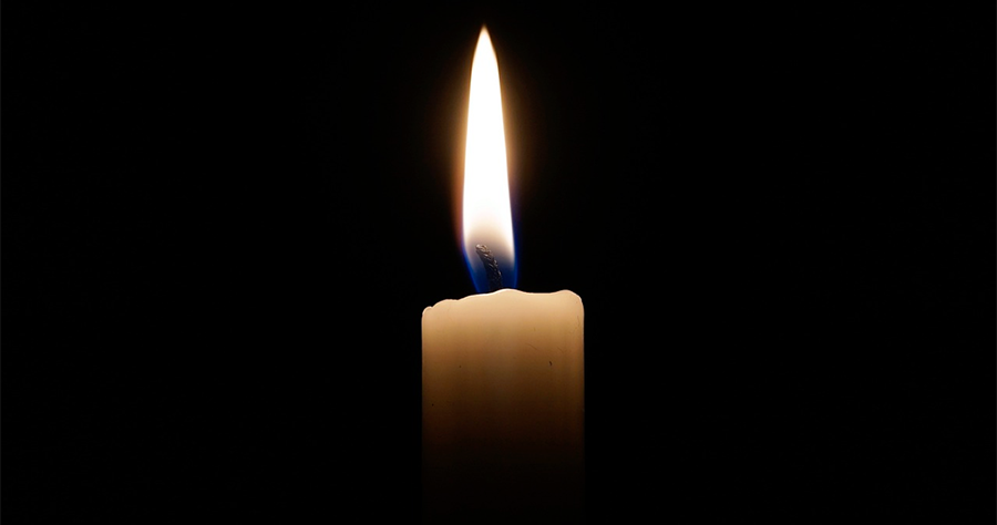 A lit candle on a black background