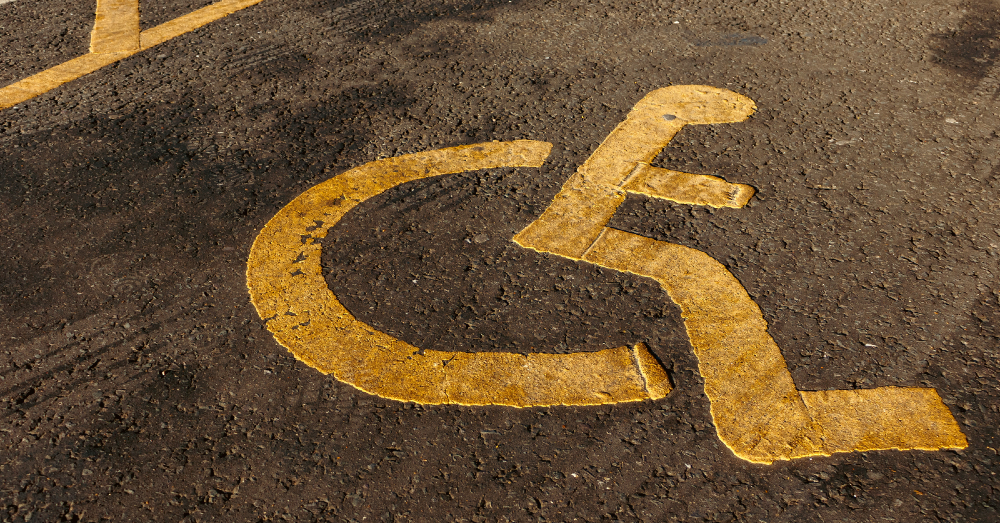 Figure in wheelchair painted on to car park symbol of disability