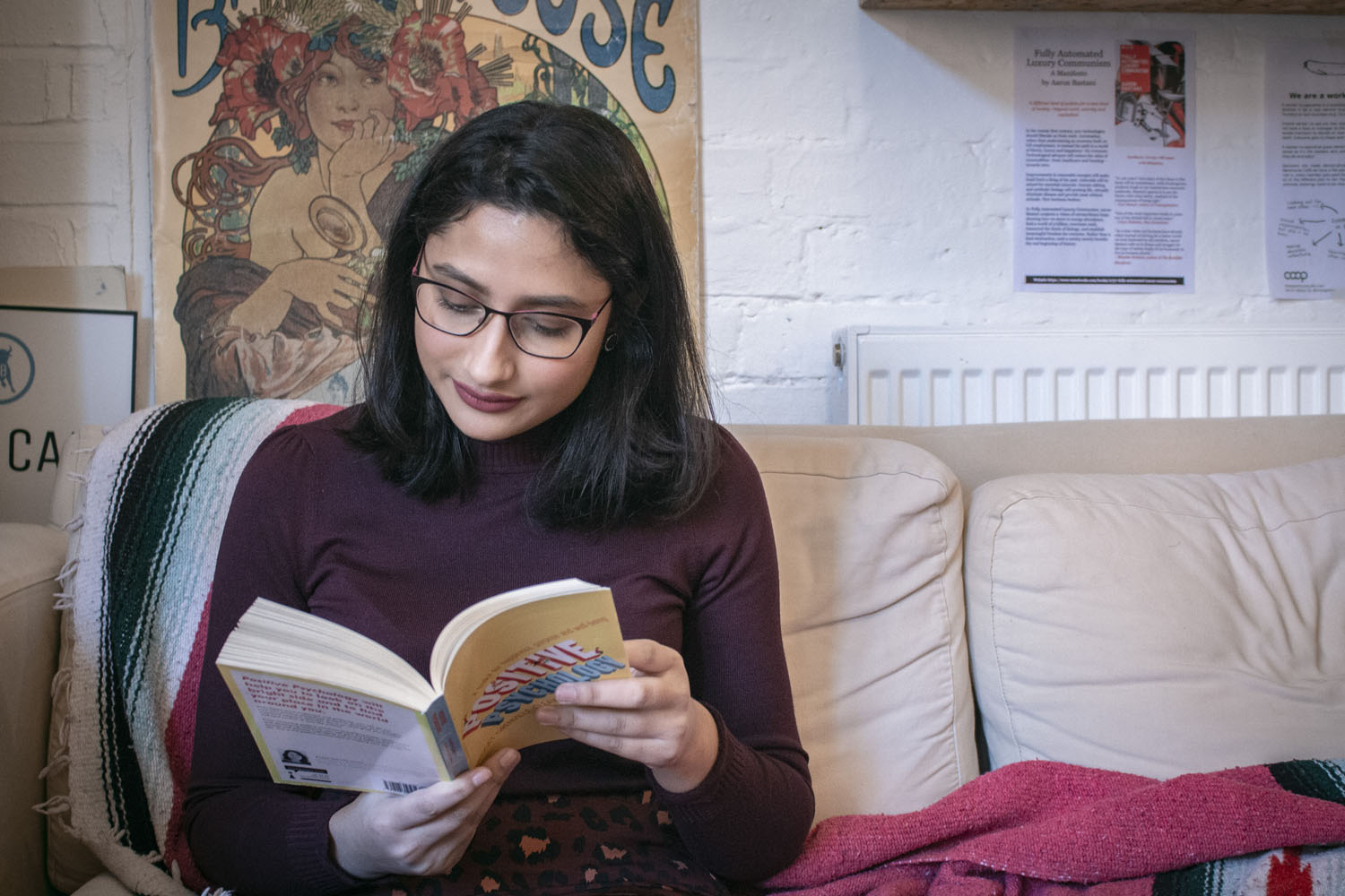 Shamima reading a book in a coffee shop