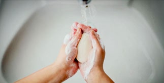 Hands being washed with soap and water.