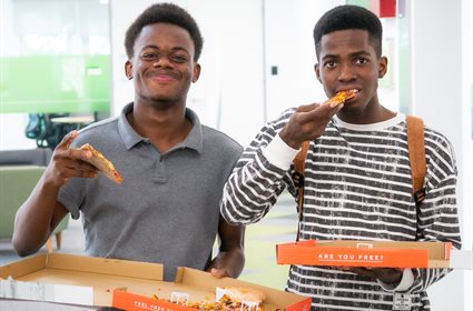 Students eating pizza after a student event