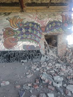 Ukrainian mural by Alla Horska (1967) destroyed by a Russian shelling, bricks and debris strewn across the frame. Photograph by Ivan Stanislavsky