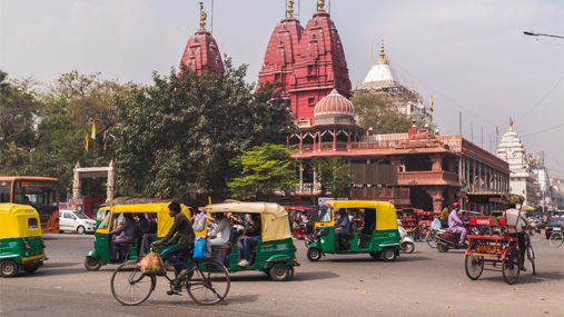 Rickshaws and tuk-tuks at a busy Indian intersection