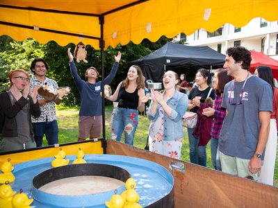 Fulbright scholarship students play hook-a-duck at the fair
