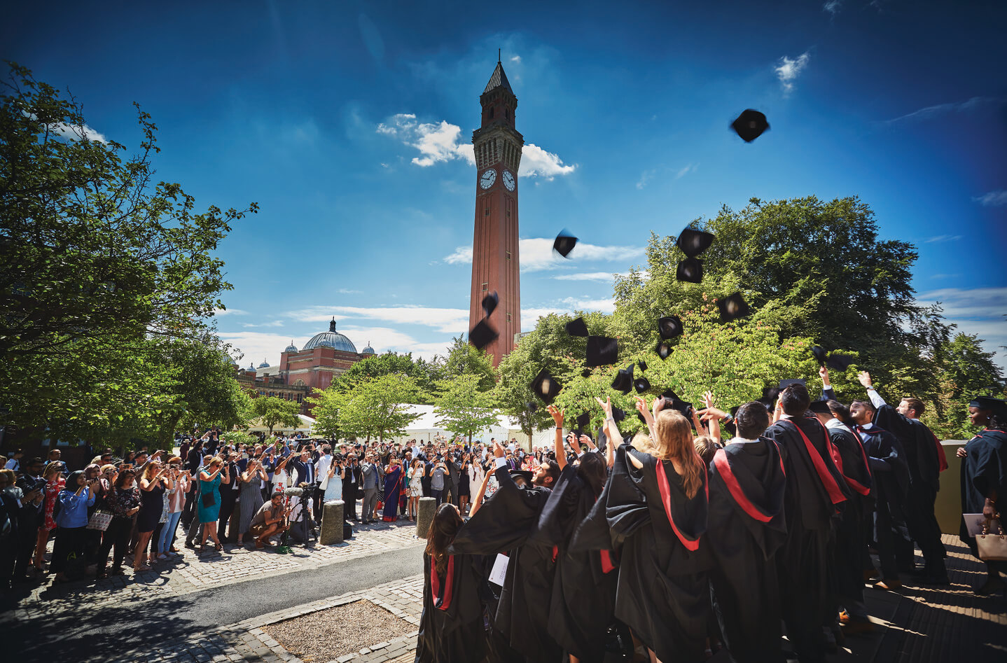 graduates stand in front of Old Joe clocktower