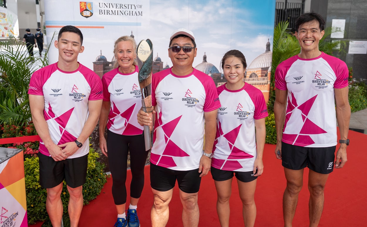 A group of batonbearers in Singapore holding the Queen's baton