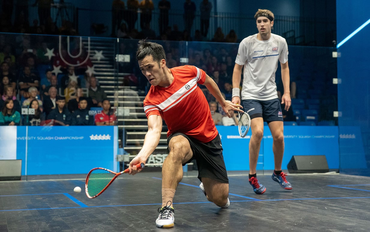 Two male squash players in action during a match