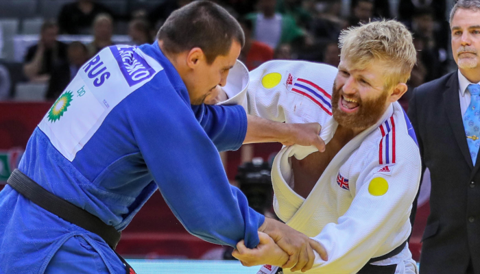 British Paralympic judoka Chris Skelley competing in a judo match as the match referee looks on