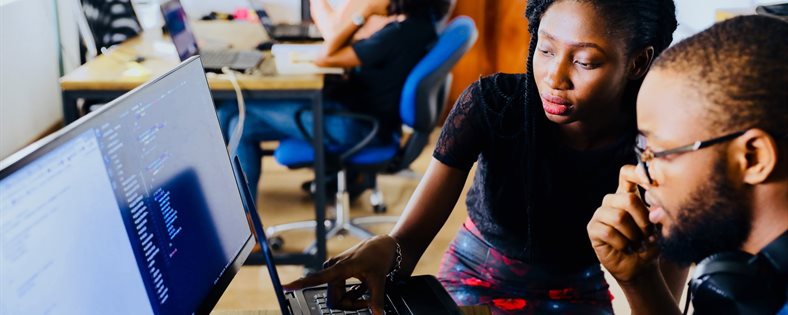 Two people working at a computer.