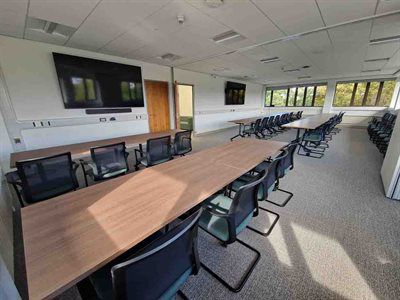 large seminar room with tables chairs and a screen