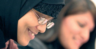 Female student wearing head scarf with another student in the background