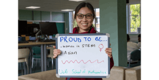 Female member of School of Mathematics holding up a sign reading 'proud to be.. woman in STEM, Asian'