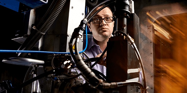 Male manufacturing researcher next to equipment