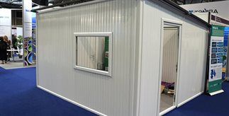 A white emergency  square shelter  with a sloping roof, made from recycled plastic.