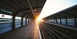 Train station platform with tracks and sunlight shining through