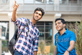 two-students-outside-pointing-and-looking-at-something-in-the-distance-cropped-330x220